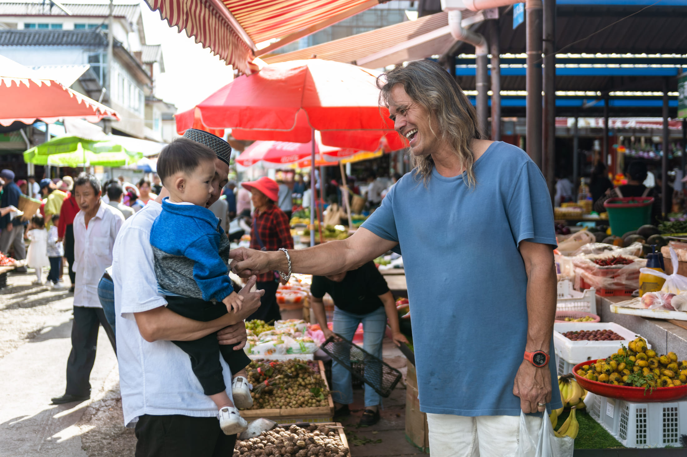 Brian Linden greets a child in Xizhou, Yunnan Province